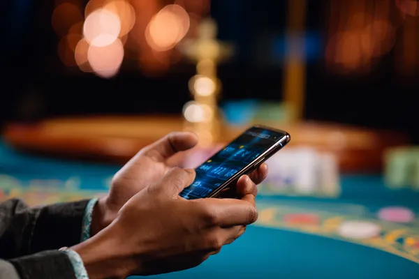 A player using their smartphone during a festive local event, representing 99XOBD’s fully mobile-friendly casino.