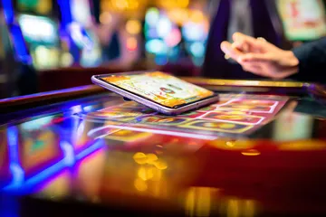 A person using their device against a moody casino-themed background, illustrating the smooth re-entry process at 99XOBD.
